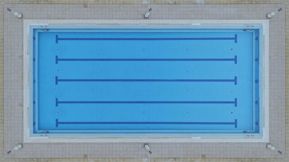 Adult swimmer doing relaxed freestyle in a pool lane, head low and breathing calmly to the side