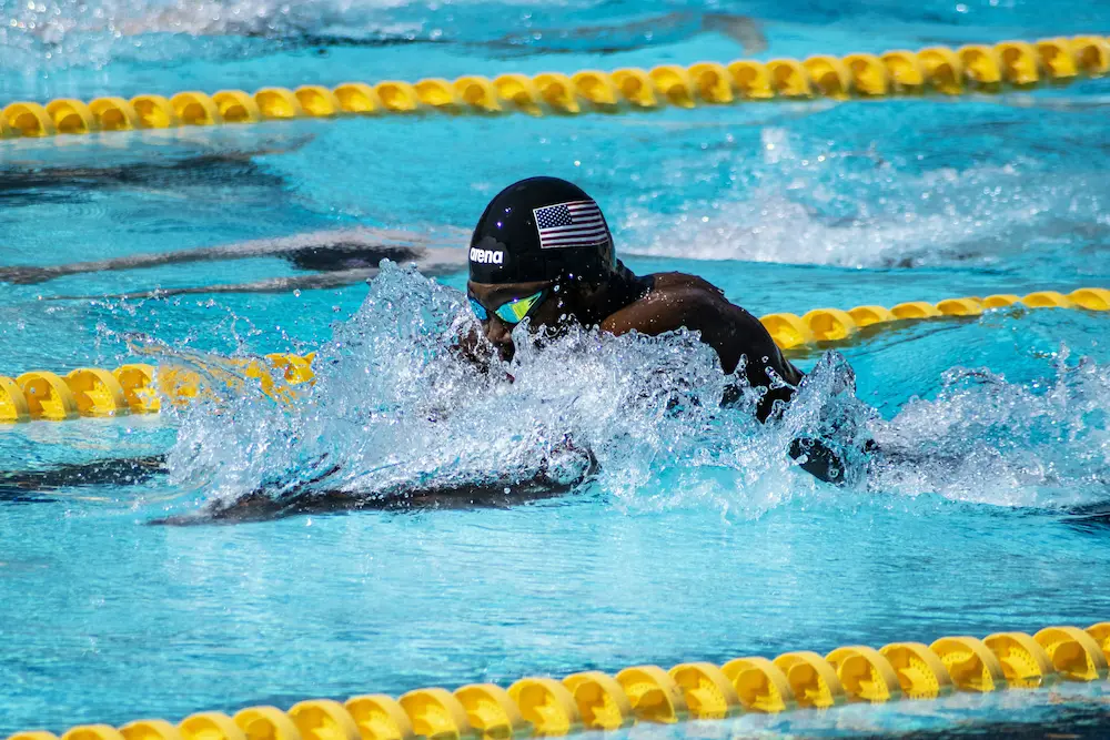 Swimmer powering through breaststroke mid-race in an outdoor competition pool