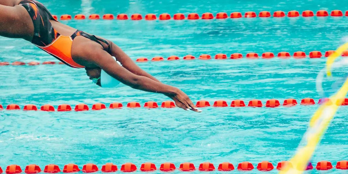 Performance swim coach working with swimmer poolside