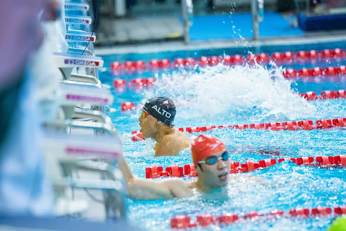Competitive swimmer mid-stroke in a pool lane